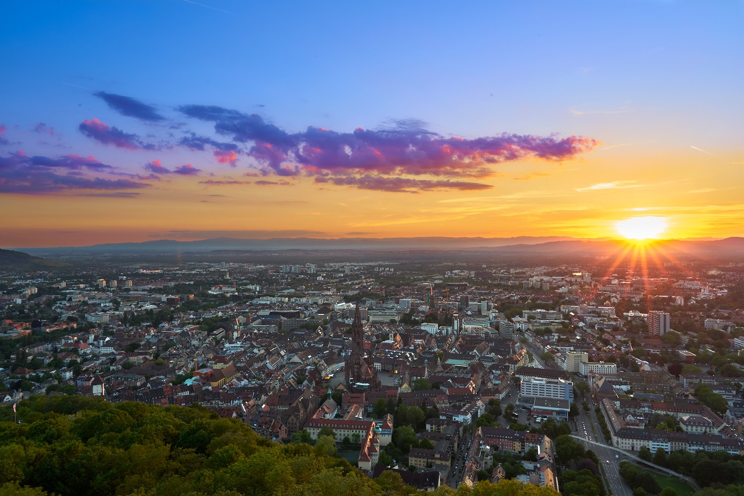 Blick vom Schlossberg auf Freiburg und das Münster bei Sonnenuntergang